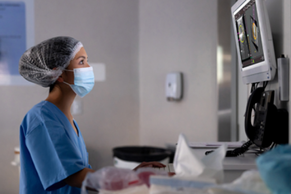 Sundhedsmedarbejder kigger på skærm i et laboratoriemiljø