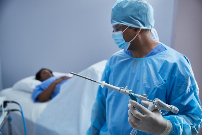 Laboratorietekniker trykker på en knap på en monitor til et medicinsk system på et laboratorium