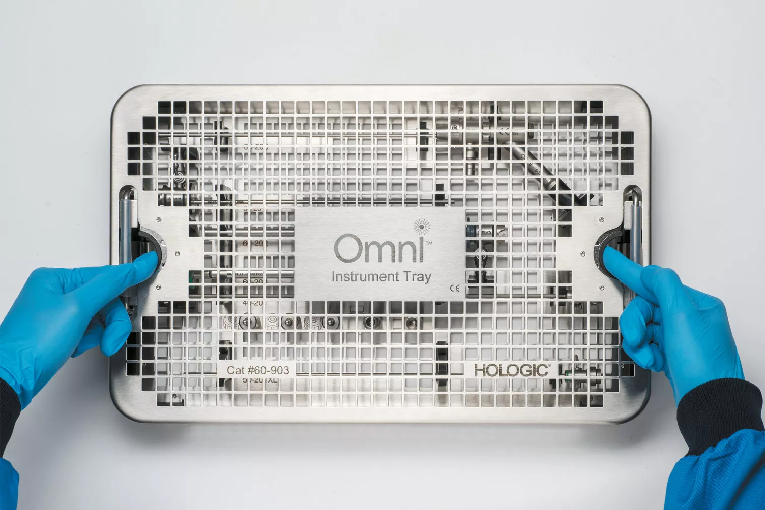 Behandskede hænder arbejder på en medicinsk bakke på et bord.