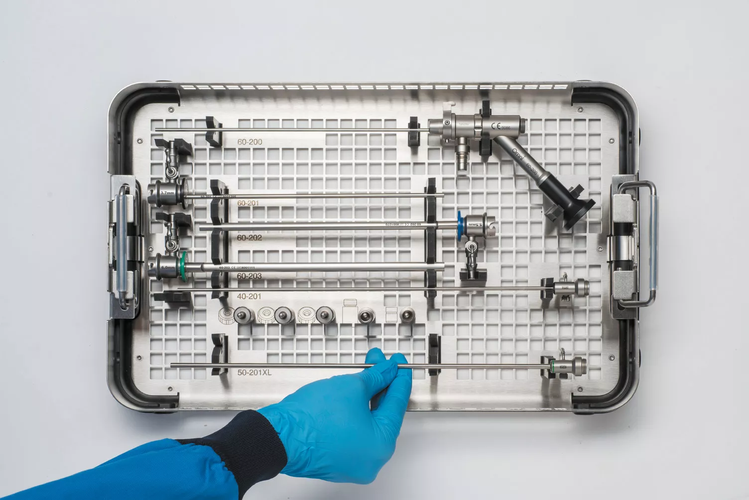 Behandsket hånd arbejder på en medicinsk bakke på et bord.