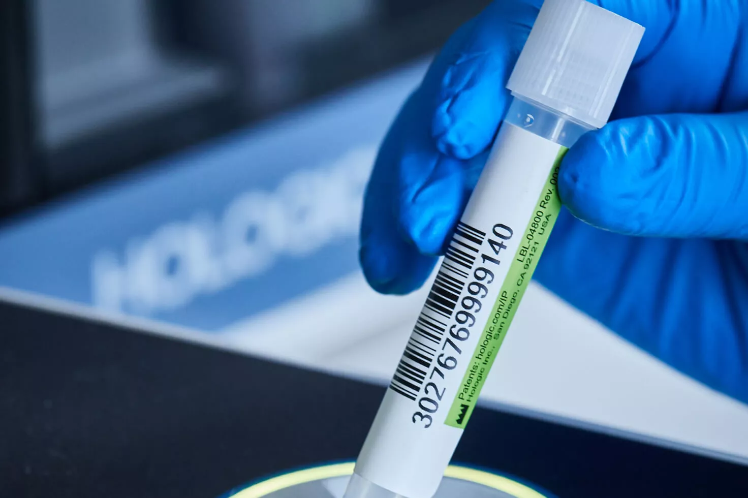 Nærbillede af handskeklædt hånd, der holder på hætteglas